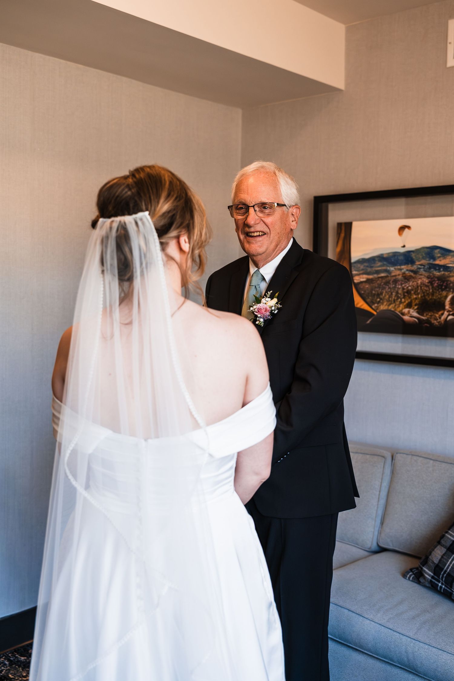 Emotional father seeing his bride daughter in wedding dress and veil for the first time.