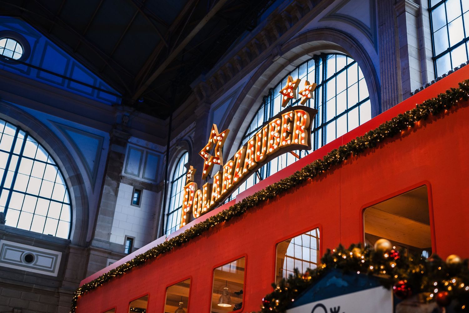 A panoramic sequence showing a decorated indoor market hall with festive Christmas lights and vaulted glass ceiling.
