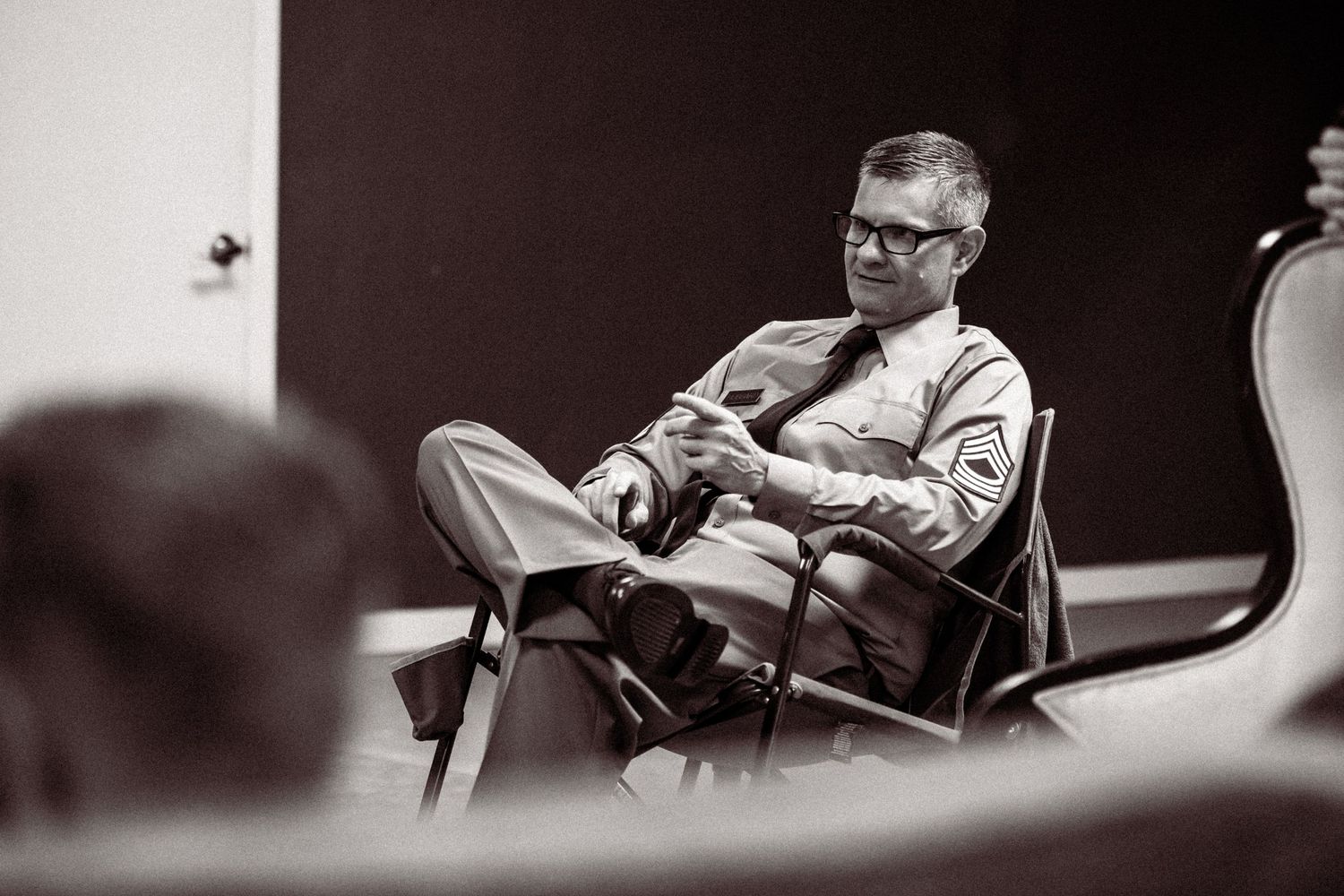 Professional seated in brown leather chair during indoor interview session.
