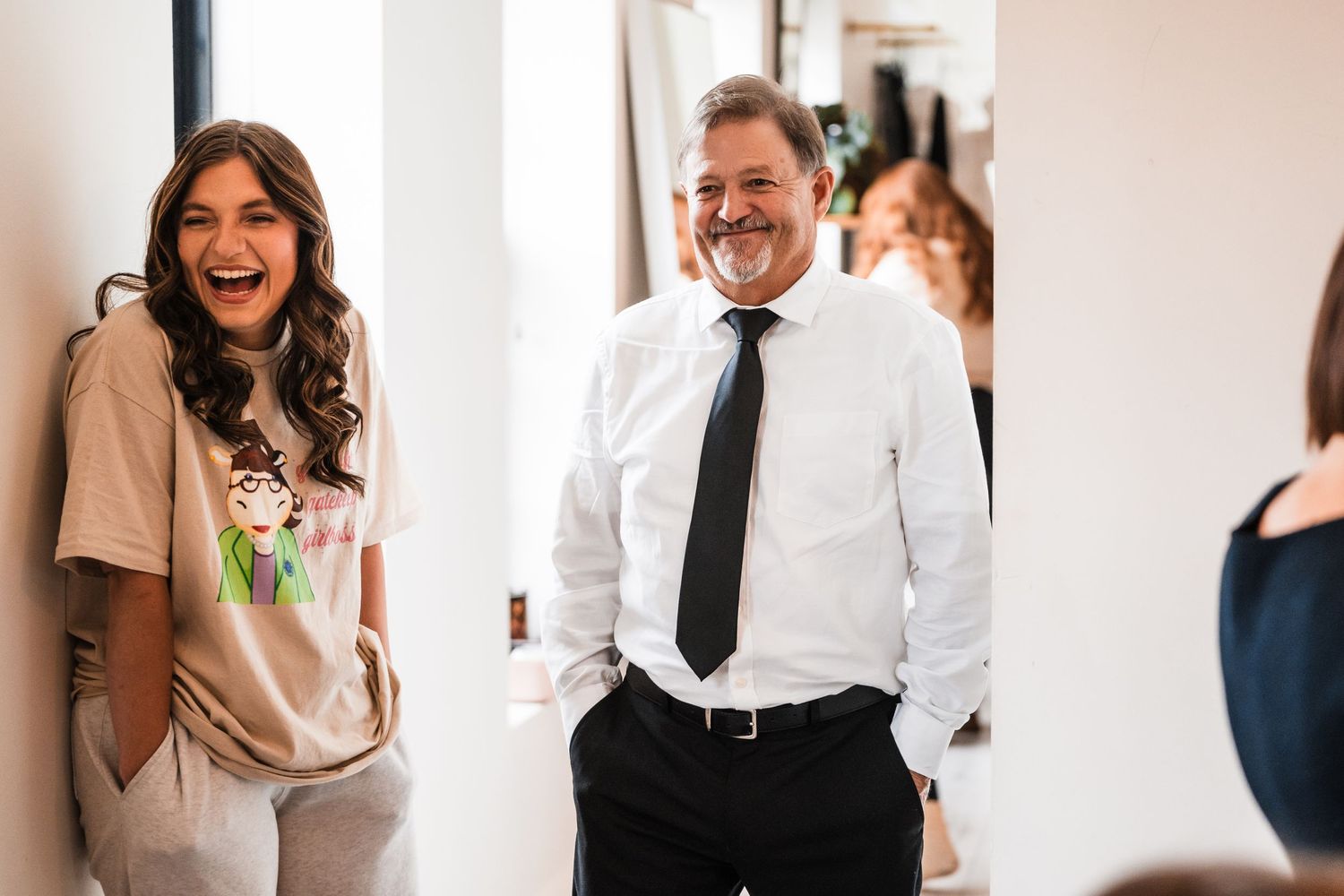 Candid laughter and joy captured in a bright indoor hallway during a special event.