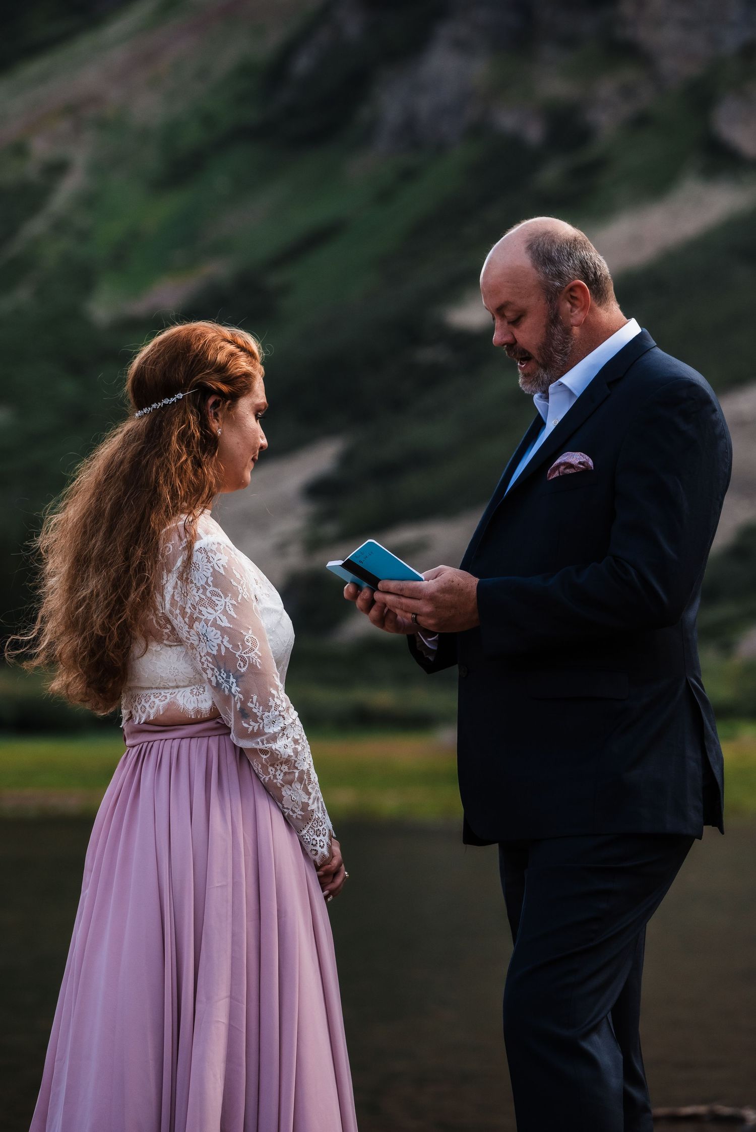 An intimate mountain ceremony with dramatic peaks in the background at dusk.