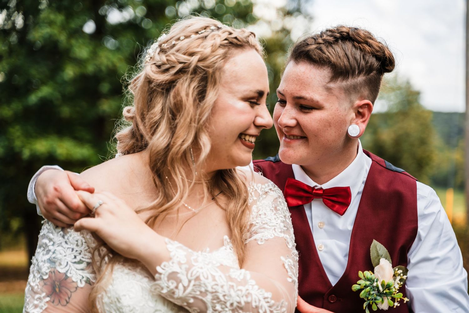 Candid outdoor wedding portrait capturing joyful laughter between newlyweds.