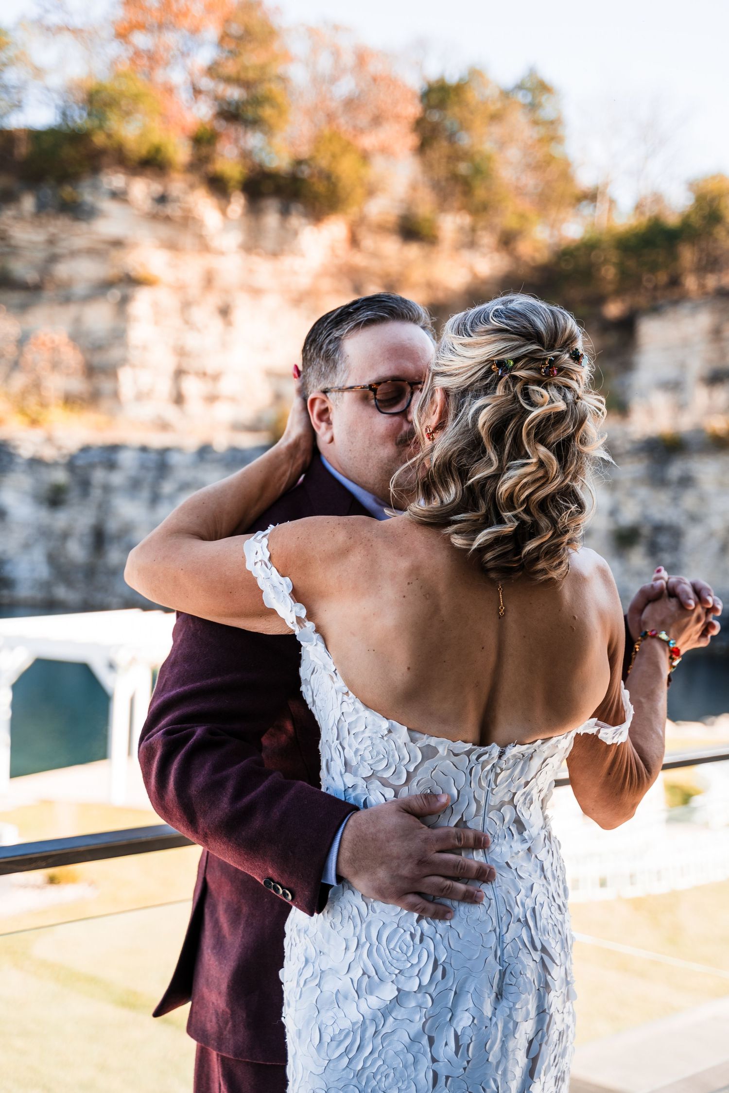 Wedding couple sharing an intimate moment during their first look, with autumn foliage in the background.