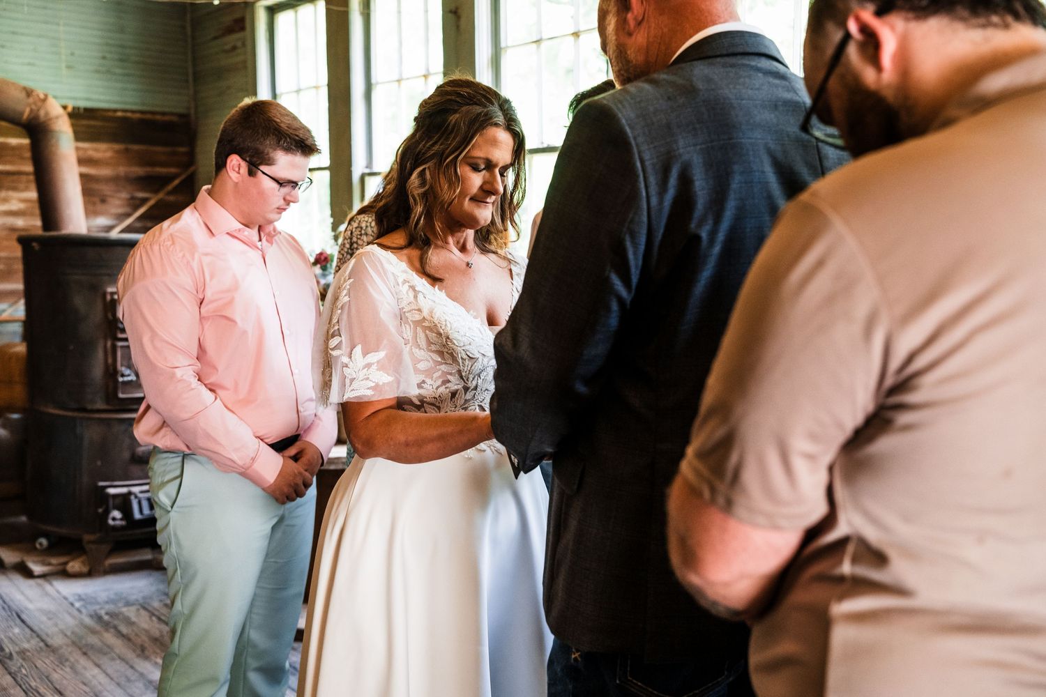 Wedding party socializing and mingling in an outdoor venue with warm lighting.