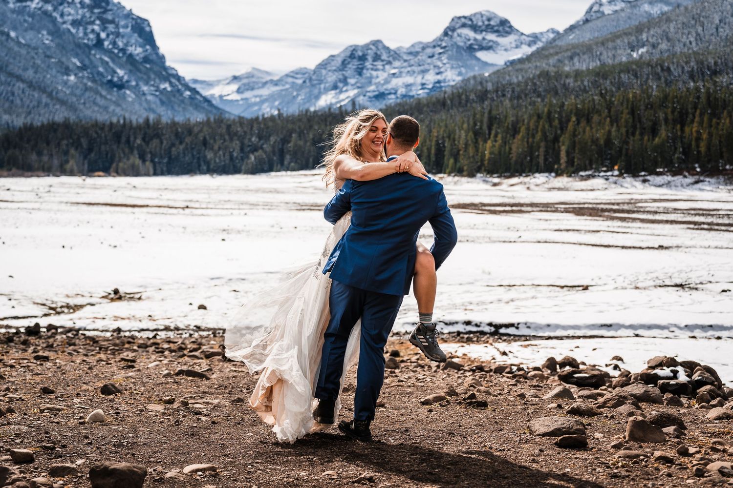 Wedding photography against a dramatic mountain landscape with snow-capped peaks.