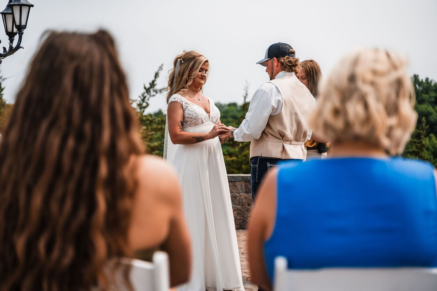 Wedding guests gathered outdoors for a celebration at an elegant venue in golden sunlight.