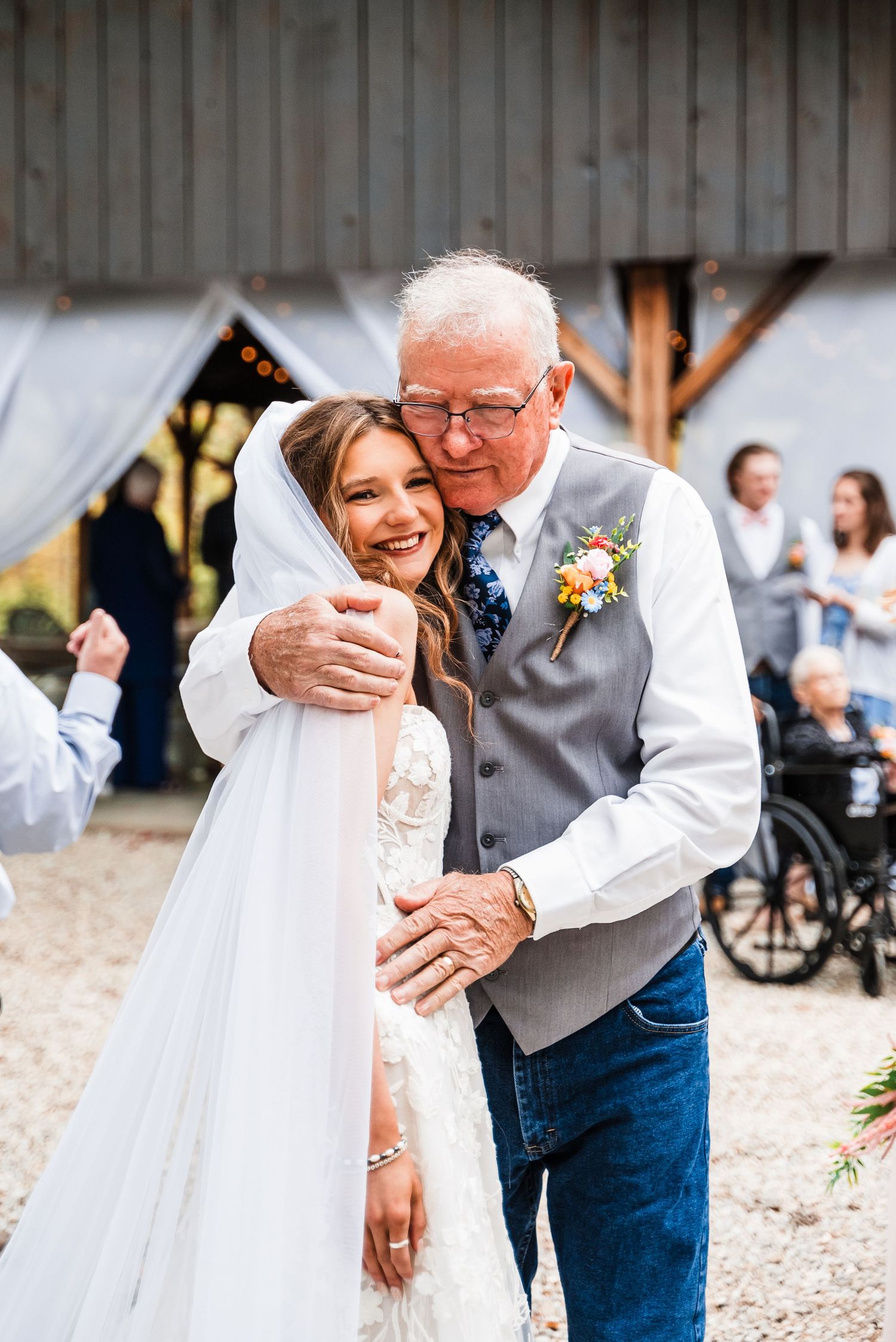 A touching moment shared between two people during a rustic outdoor wedding celebration.