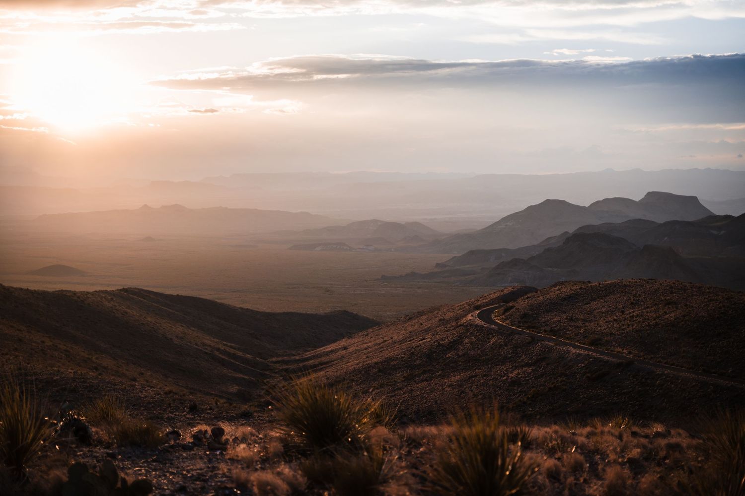 Golden sunlight illuminates desert mountains and valleys during sunset at Big Bend National Park.