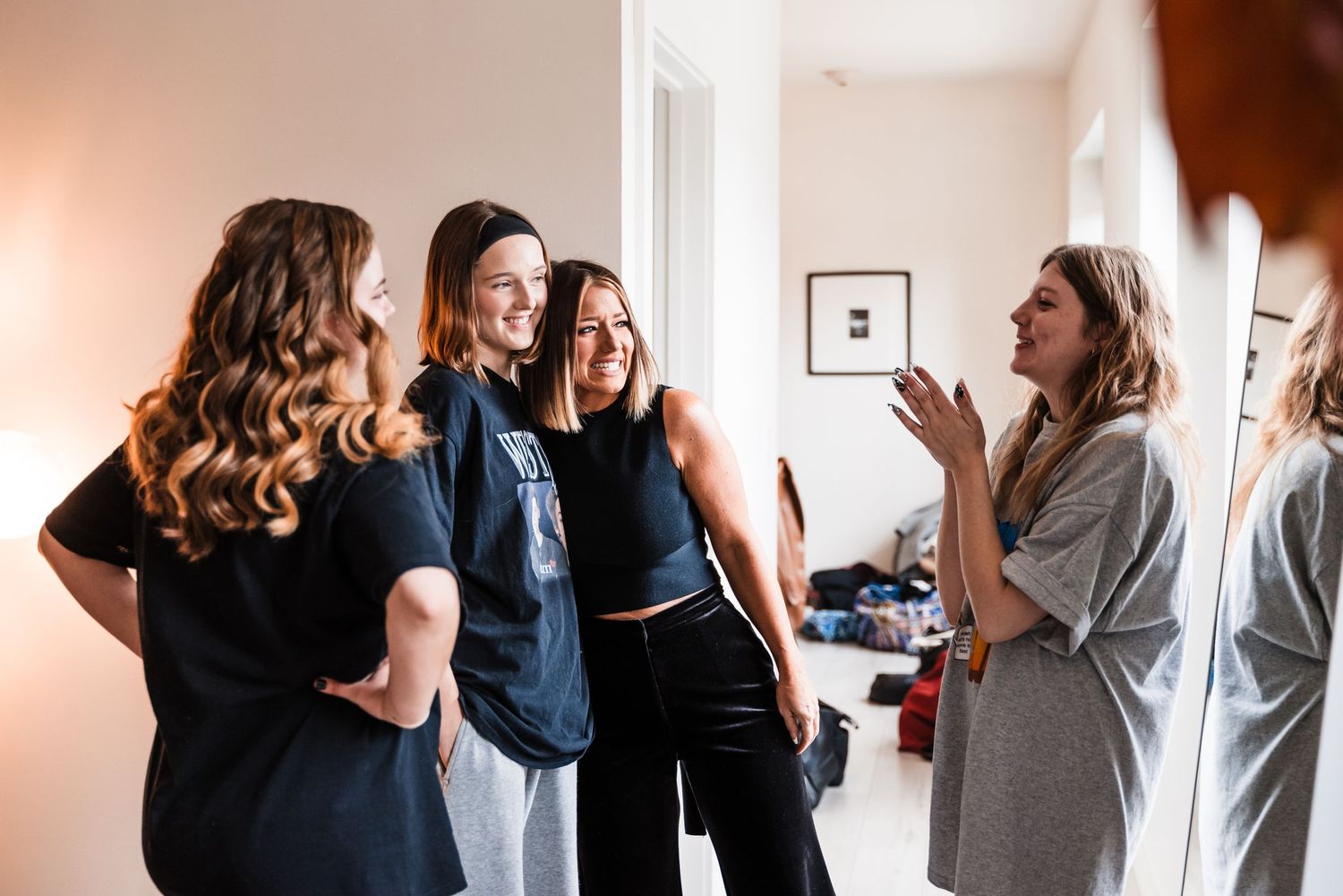 Group gathering in casual attire during wedding day preparations in a bright room.