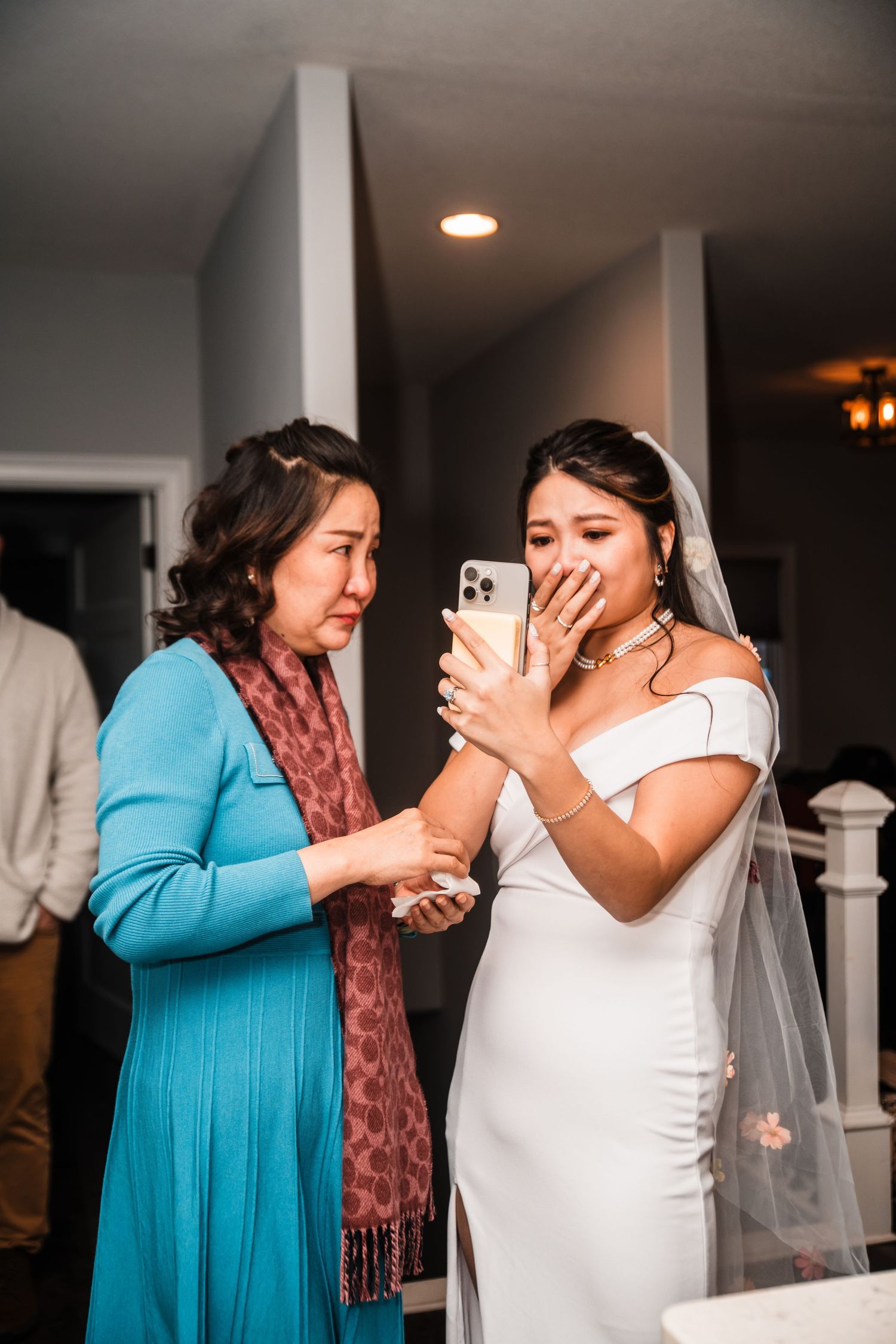 An emotional moment between two people during a wedding celebration indoors.