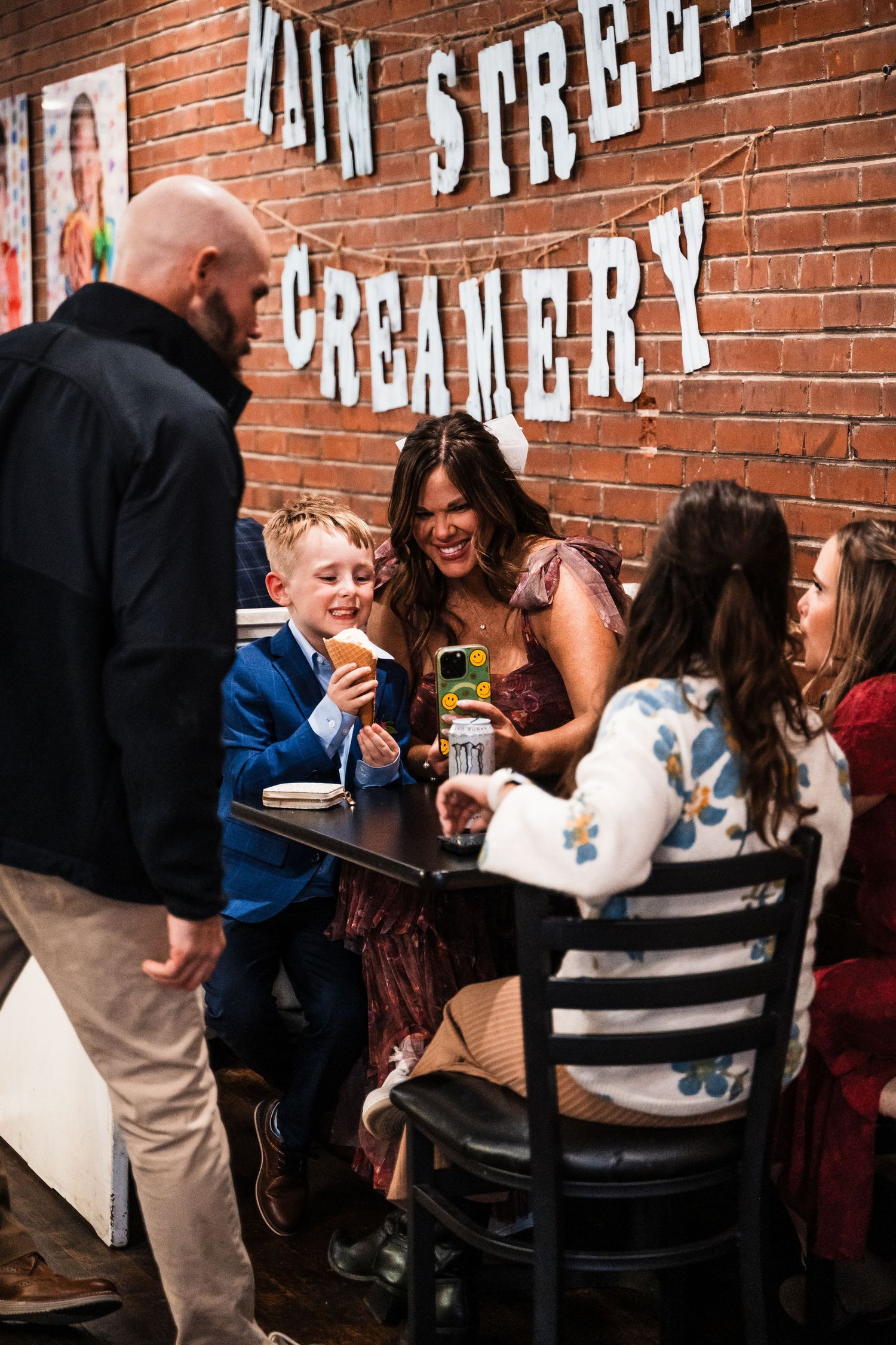 Group gathering at Main Street Creamery with brick wall signage visible.