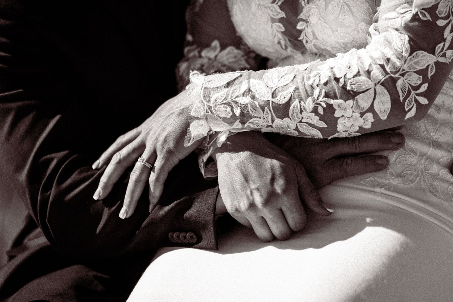A black and white collage of wedding details showing hands, rings, and dress fabric details.