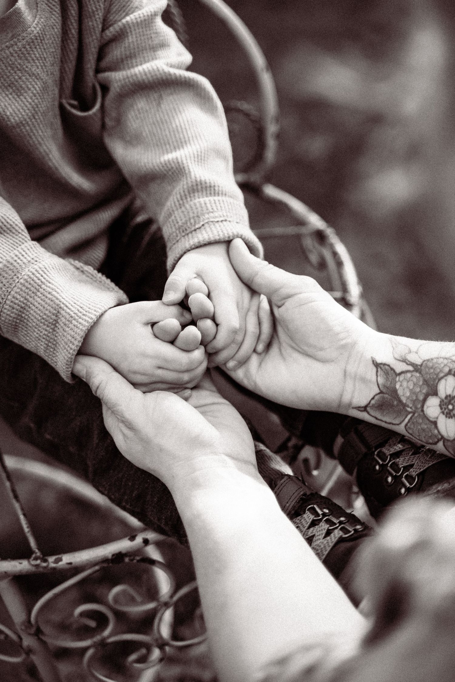 Black and white photo series showing hands holding and examining a piece of jewelry or small object.