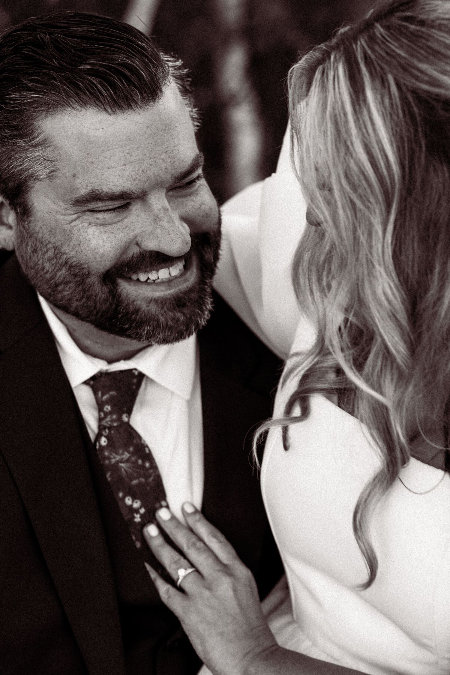 Intimate black and white wedding portraits showing tender moments between a couple in formal attire.