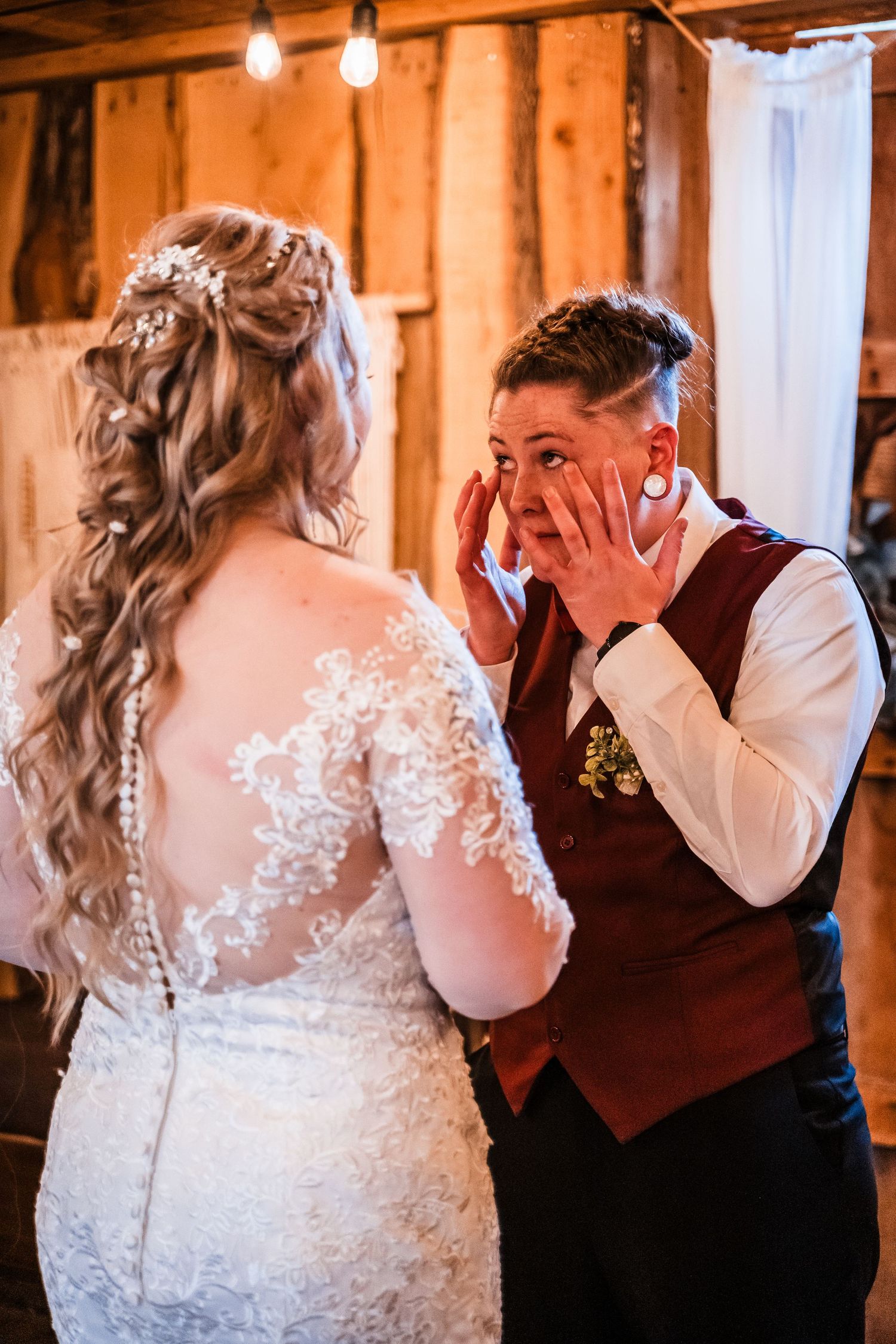 Emotional first look moment during wedding ceremony in rustic barn setting.