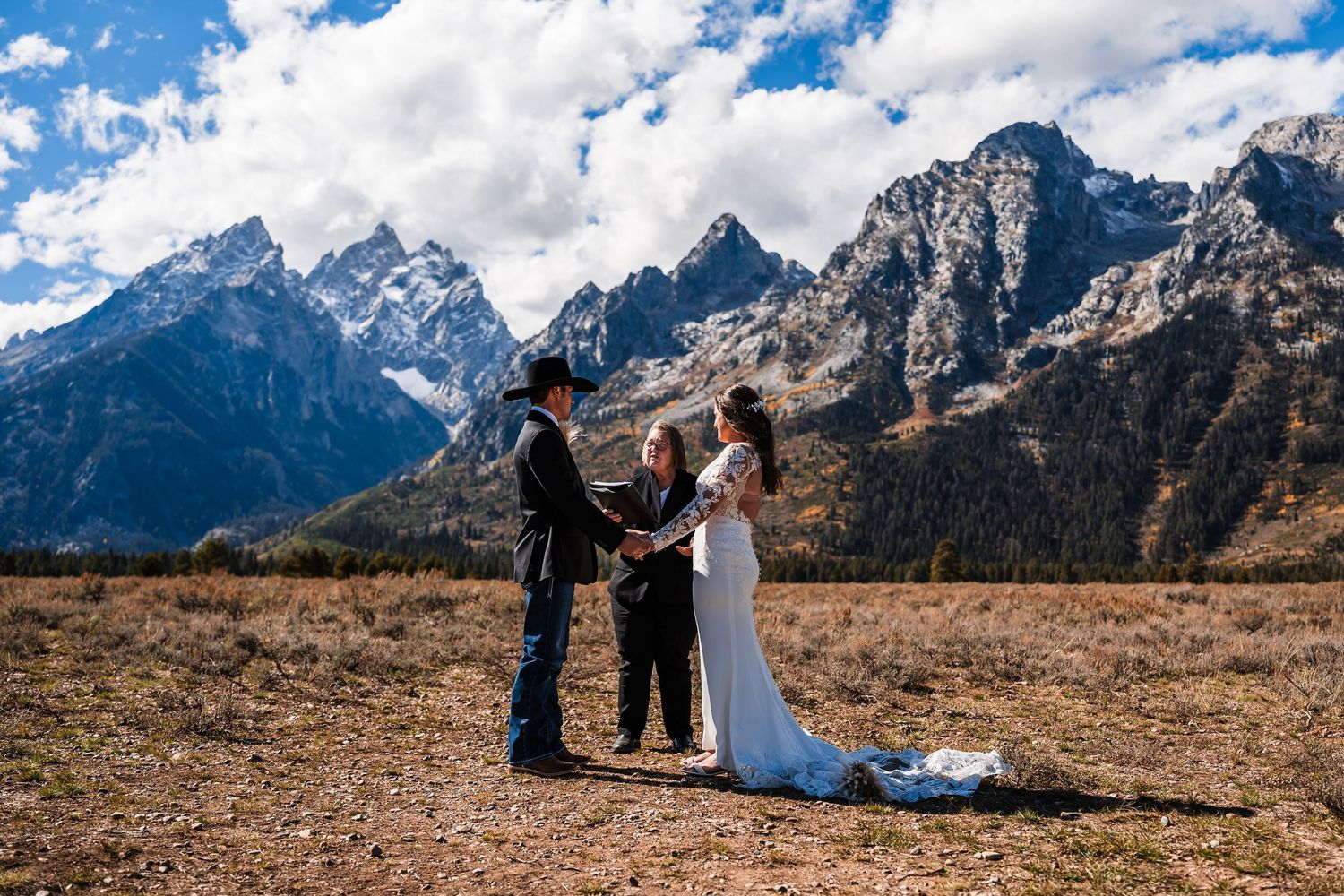 A couple poses in front of the majestic Grand Teton mountains during their outdoor wedding photo session.
