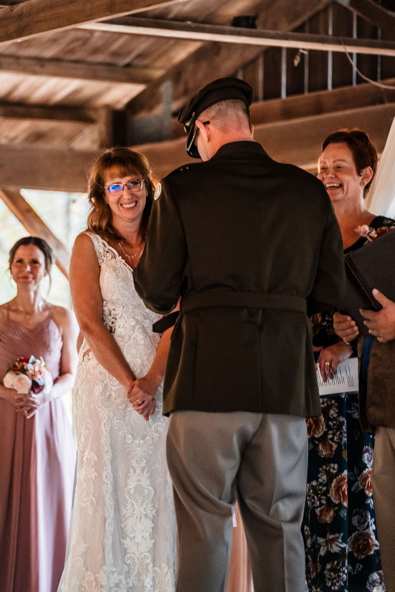 A wedding ceremony takes place indoors with guests watching the couple exchange vows.