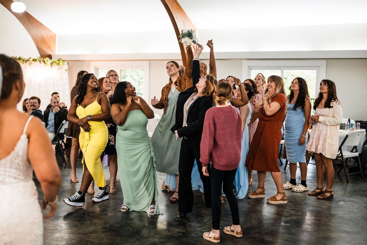 Celebration at a wedding reception with guests dancing and having fun in a bright indoor venue.