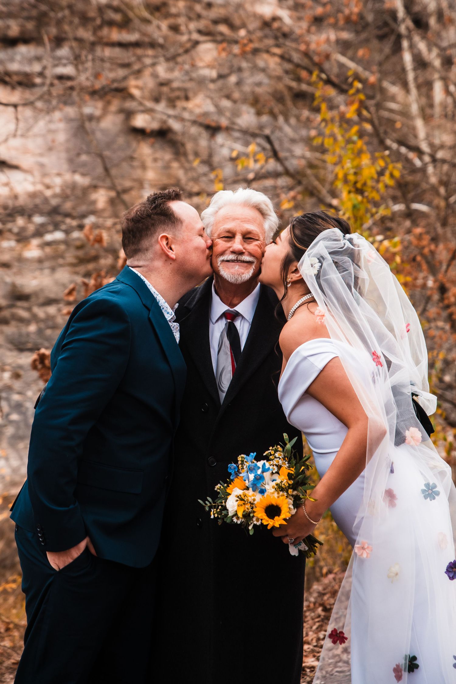 Intimate moment shared between couple and officiant during outdoor autumn ceremony.