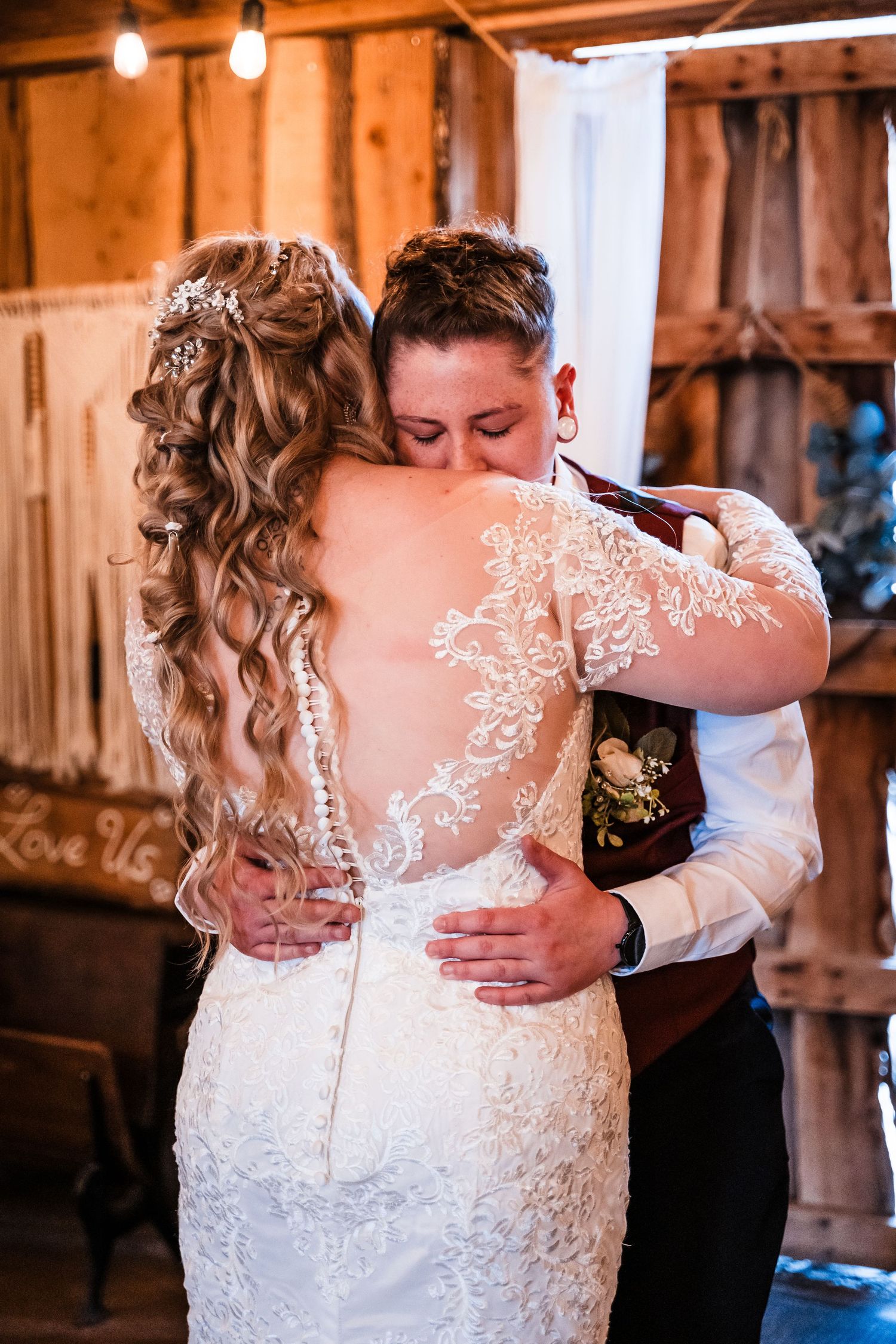 An intimate moment captured during a rustic barn wedding dance with lace dress details.