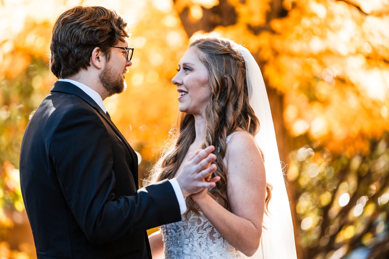 Tender moment between bride and groom against warm fall colors.