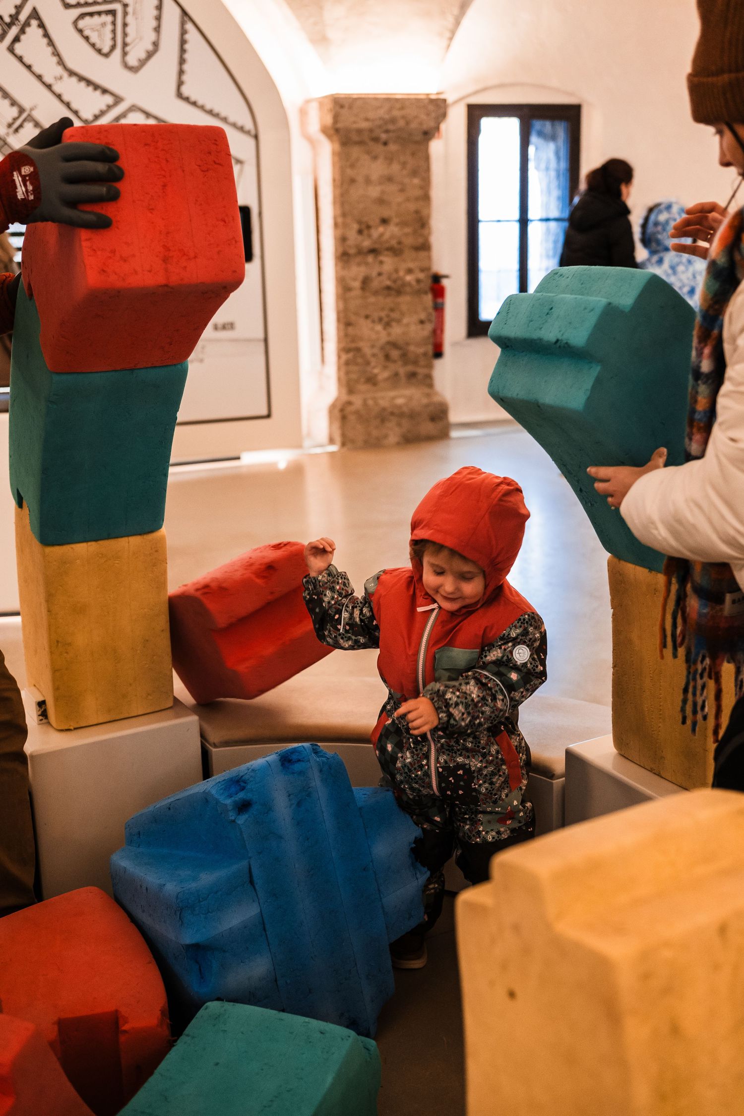 Colorful geometric play blocks and shapes in a children's museum exhibit area.