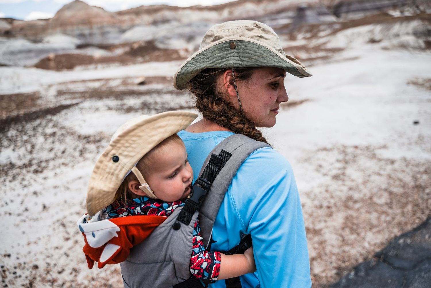 A pair of hikers explore rugged desert terrain while wearing protective gear and carrying supplies.