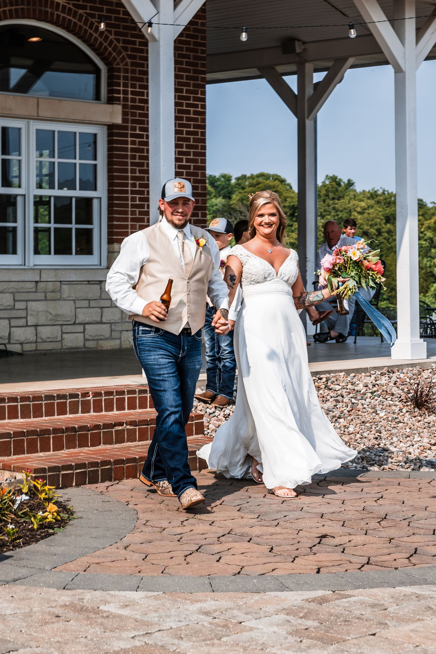 A couple performs a fun dance move sequence on a brick patio outside a building with white pillars.