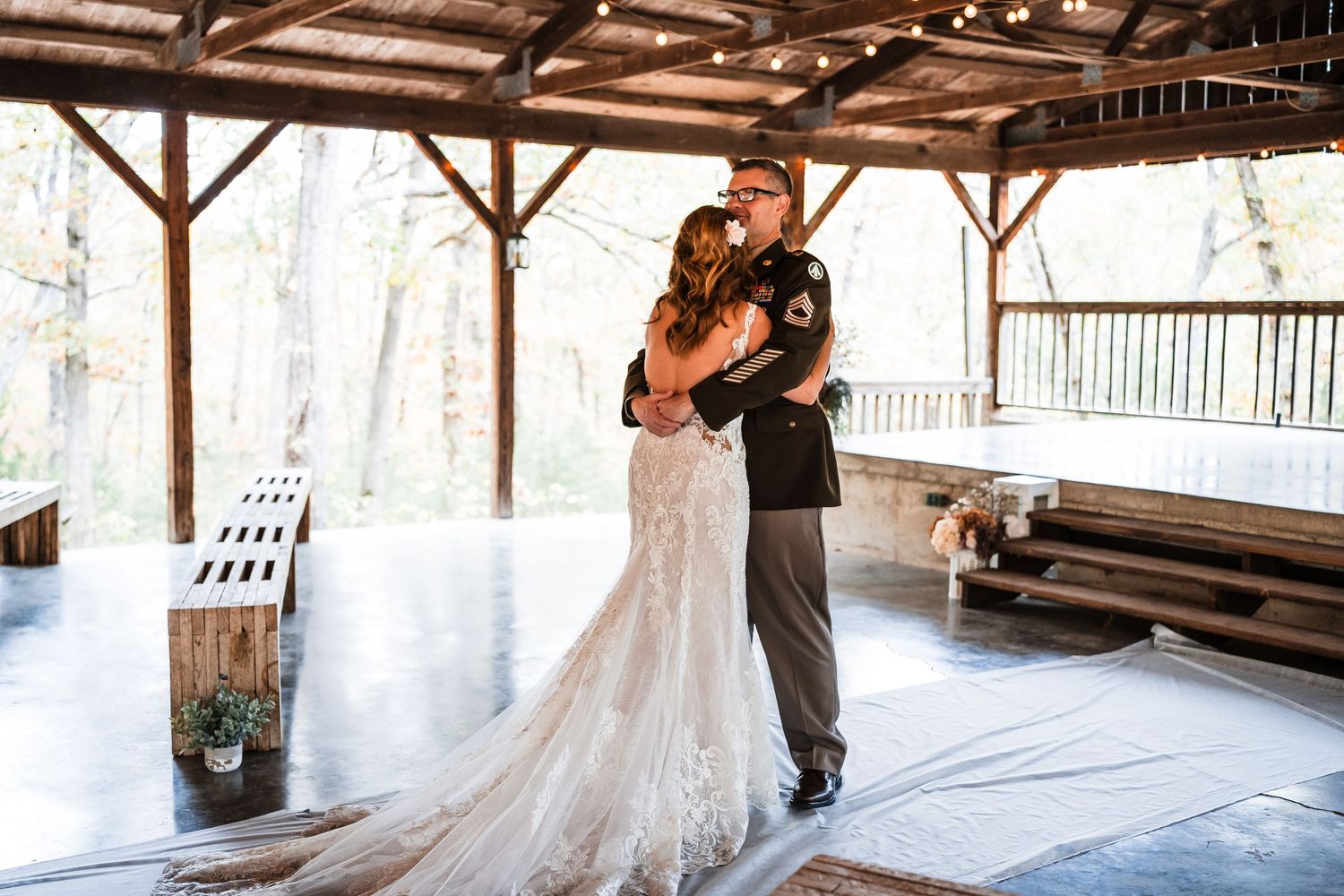 A rustic covered pavilion with wooden beams and natural lighting creates an intimate wedding venue setting.