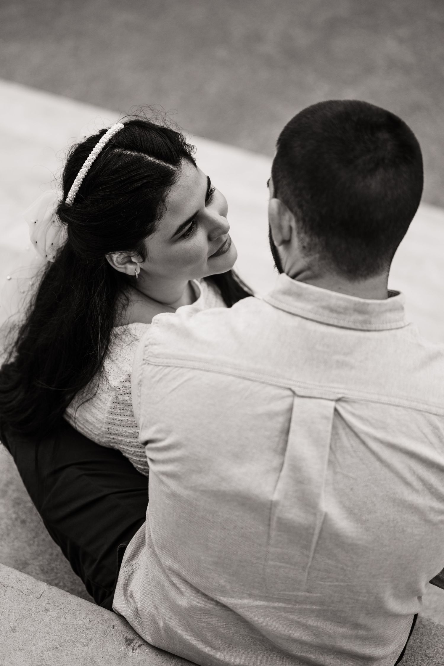 Black and white portrait of couple sharing intimate moment outdoors.