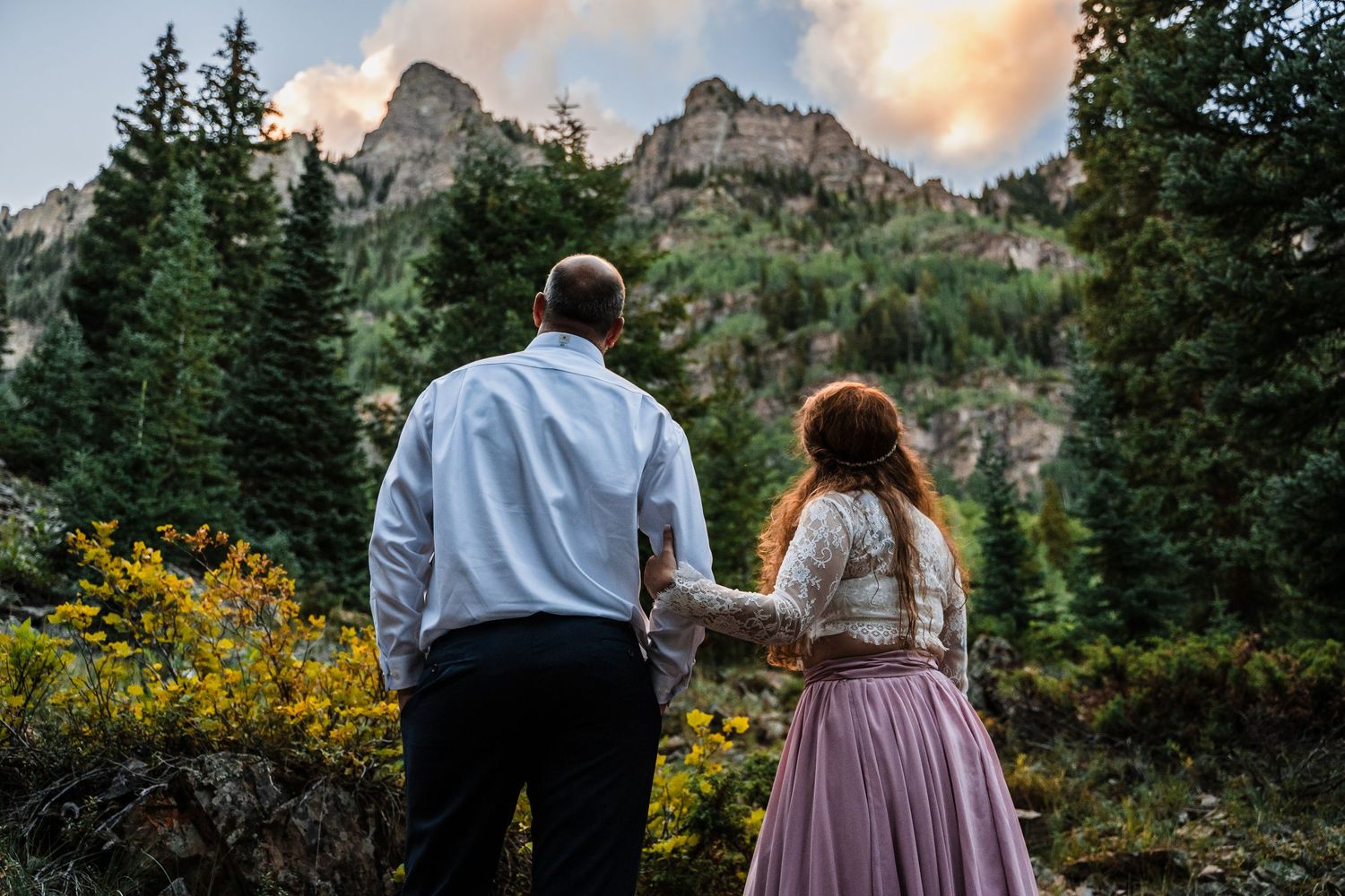 Couple admiring majestic mountain vista during golden hour.