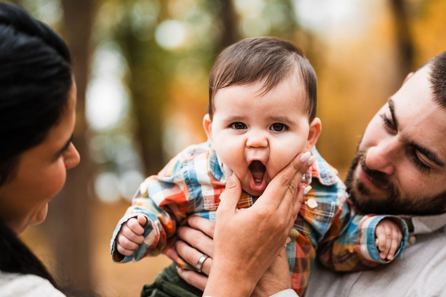 Candid family moment showing expressions of joy and laughter during outdoor photoshoot.