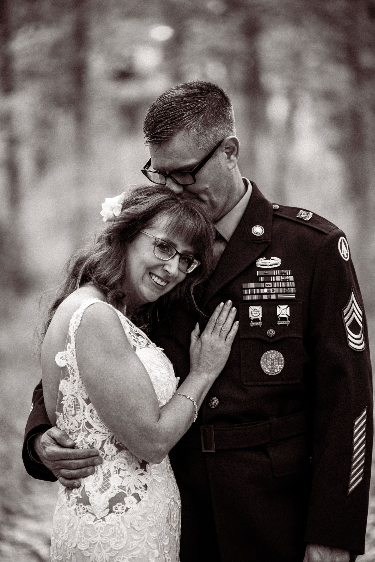 Black and white romantic wedding photos showing tender moments between a military service member and bride in a lace dress.