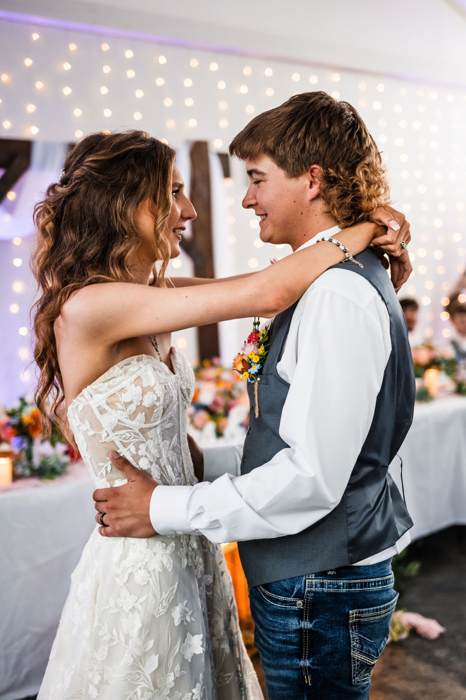 A romantic first dance moment under twinkling lights at an indoor wedding reception.