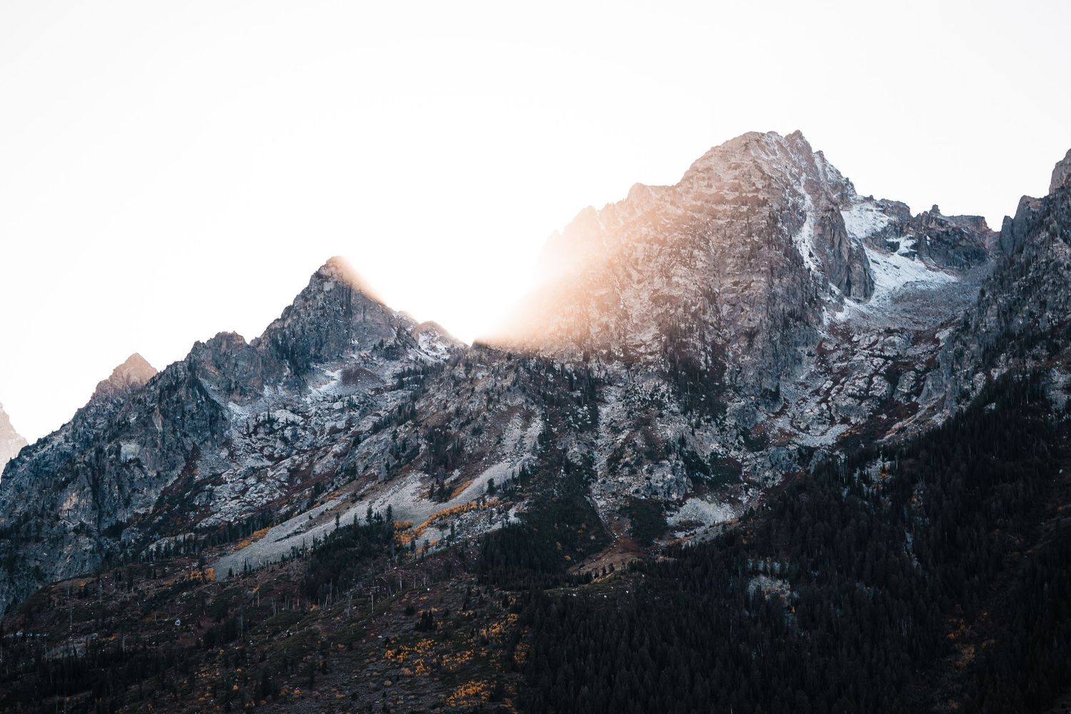 Jagged mountain peaks against clear sky during golden hour.
