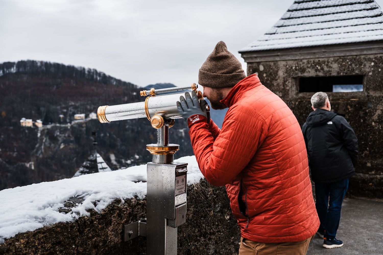 Visitors using mounted viewfinders to observe scenic mountain views.