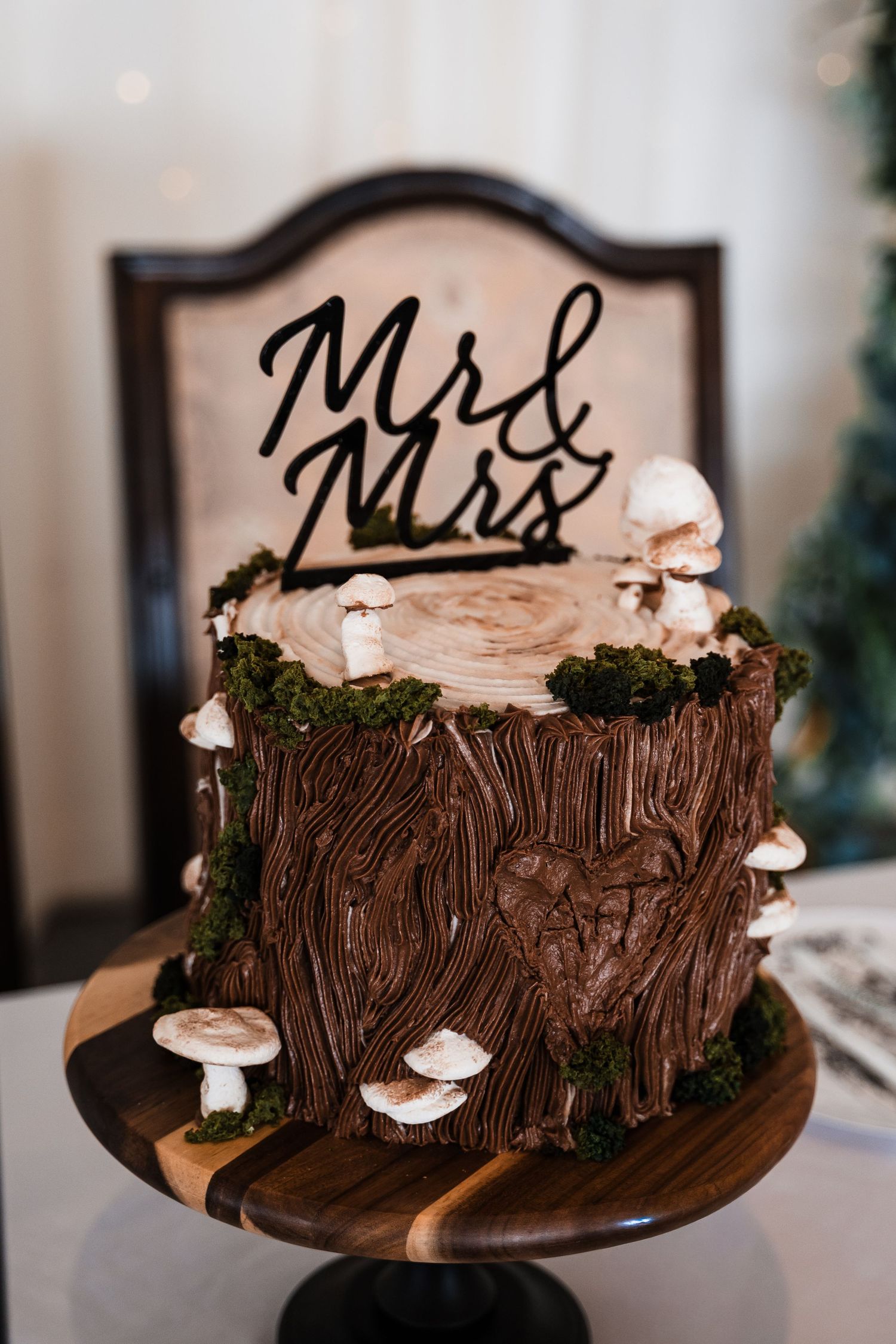 Rustic tree stump wedding cake decorated with mushrooms and moss topped with Mr & Mrs cake topper.