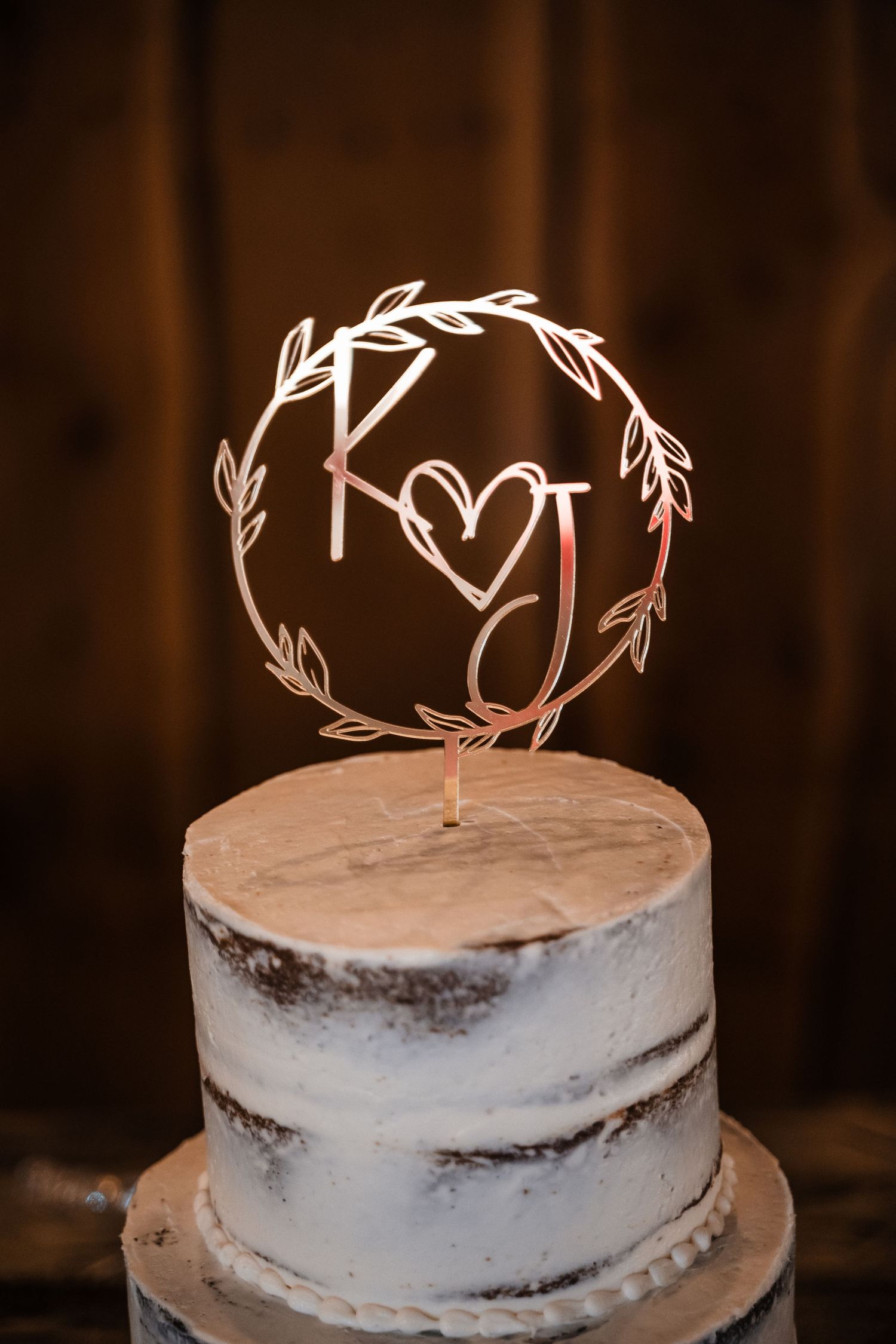 Semi-naked wedding cake with elegant K and J monogram wire topper in rose gold.