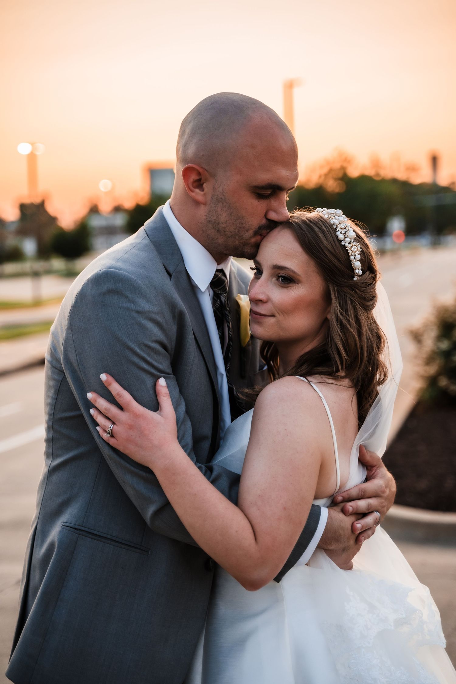 Romantic sunset wedding portrait with warm golden light and urban background.