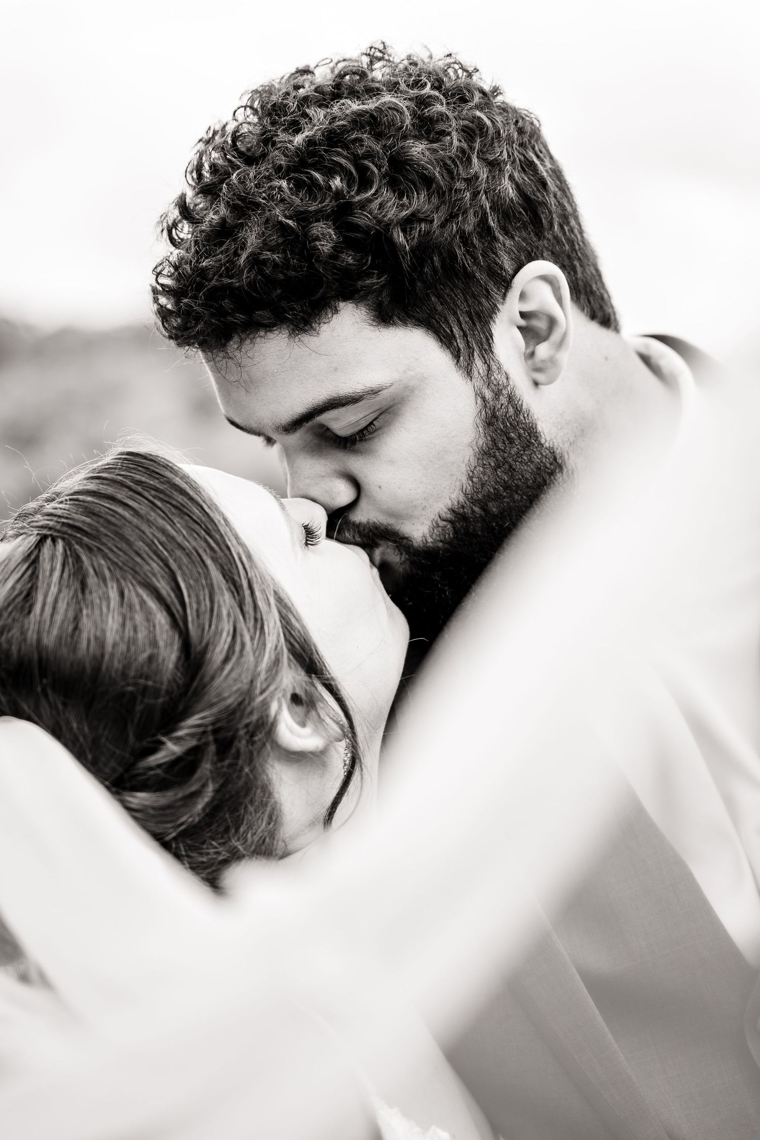 Intimate black and white portrait of romantic couple sharing tender moment.