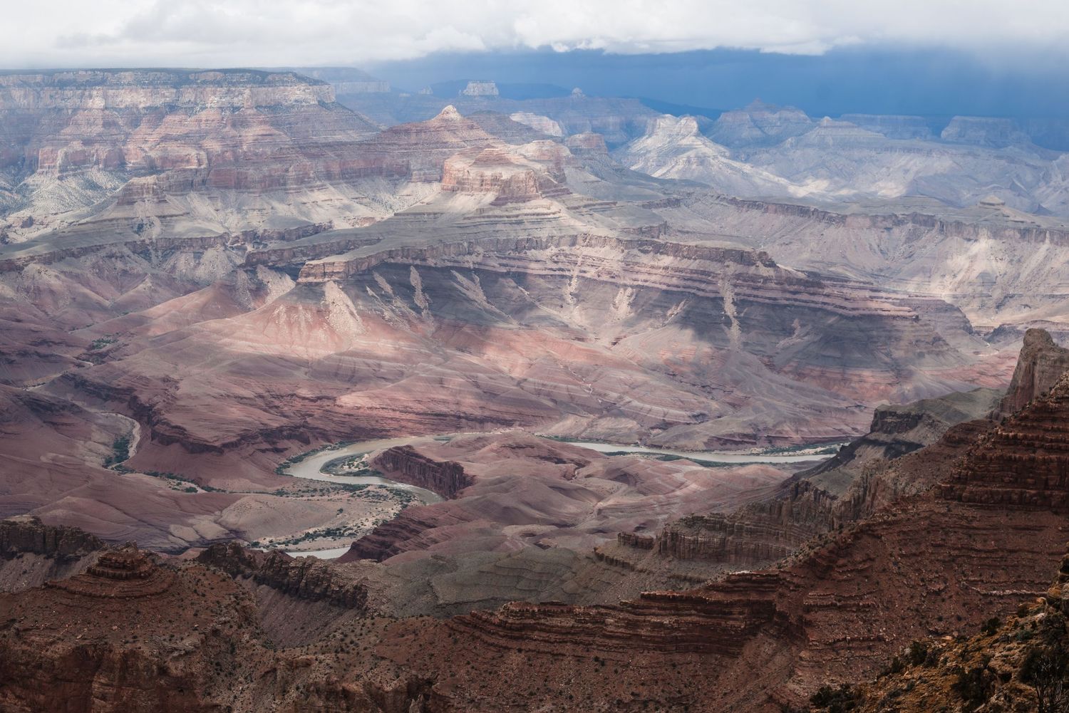 Winding Colorado River viewed from above through the Grand Canyon's red rock formations.