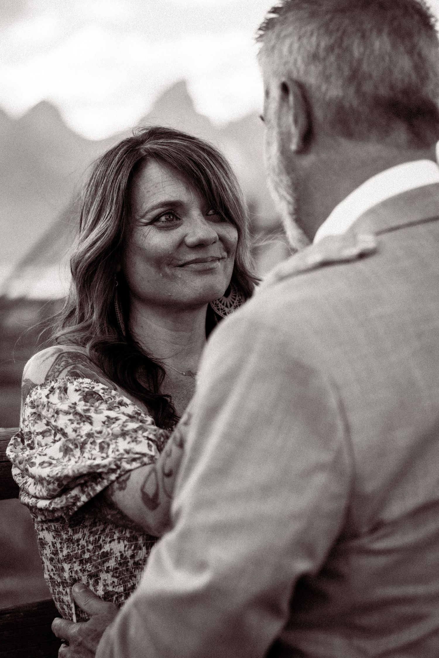 A black and white photo series showing a couple in an intimate moment with the person in floral print smiling.