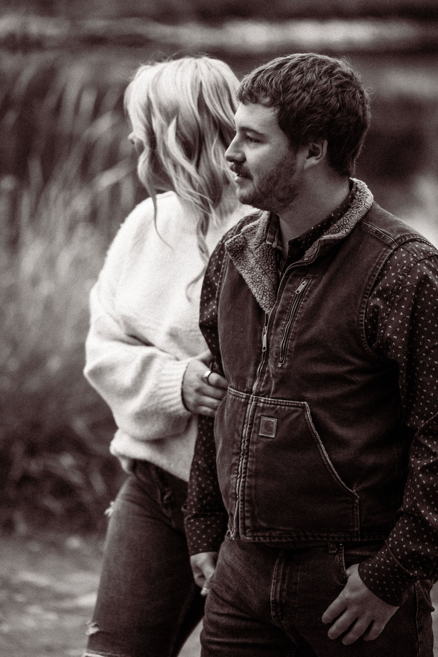 A romantic black and white photo sequence showing a couple in an intimate moment outdoors.
