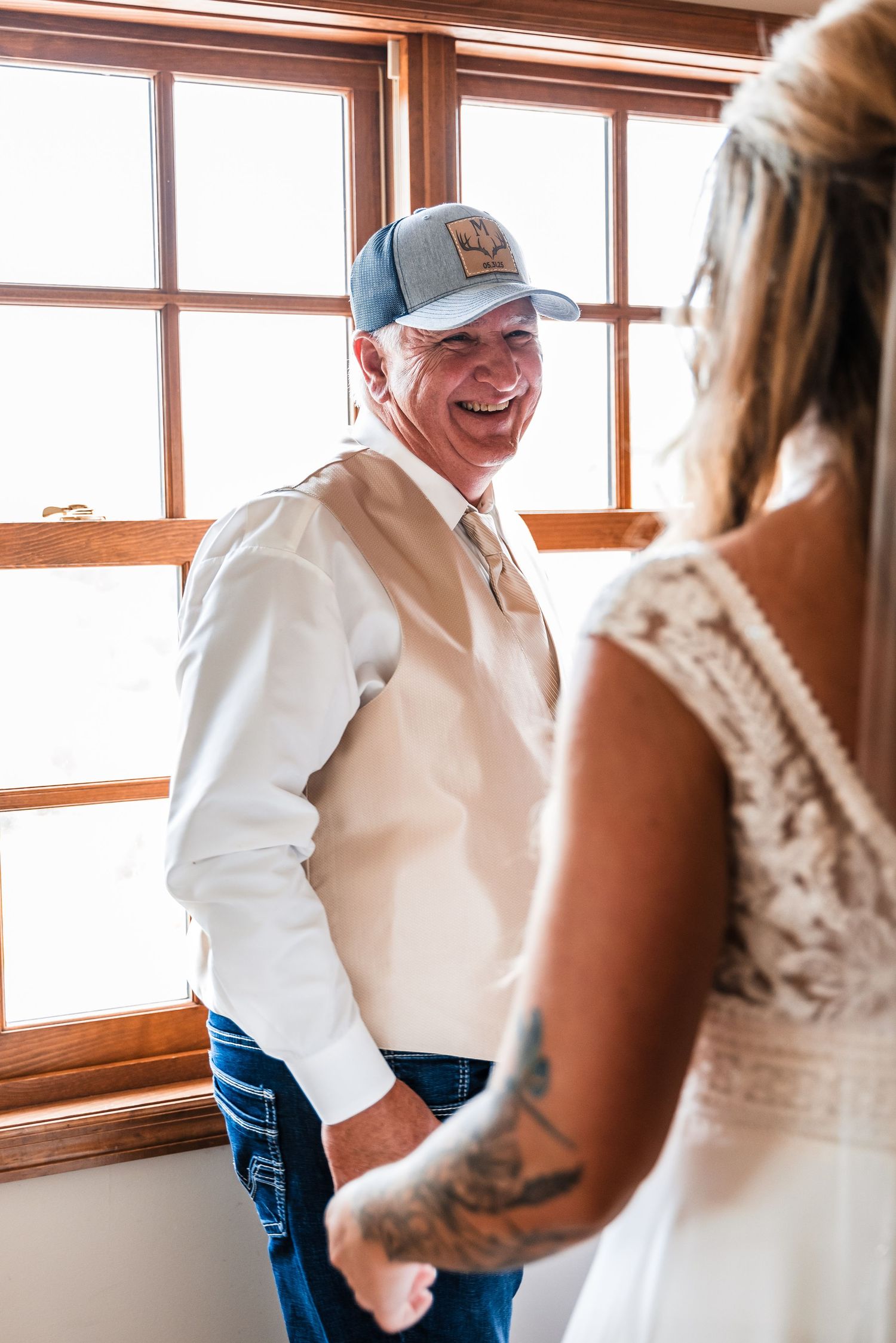 A joyful reaction is shared during a private moment near a window, with sunlight streaming through wooden frames.