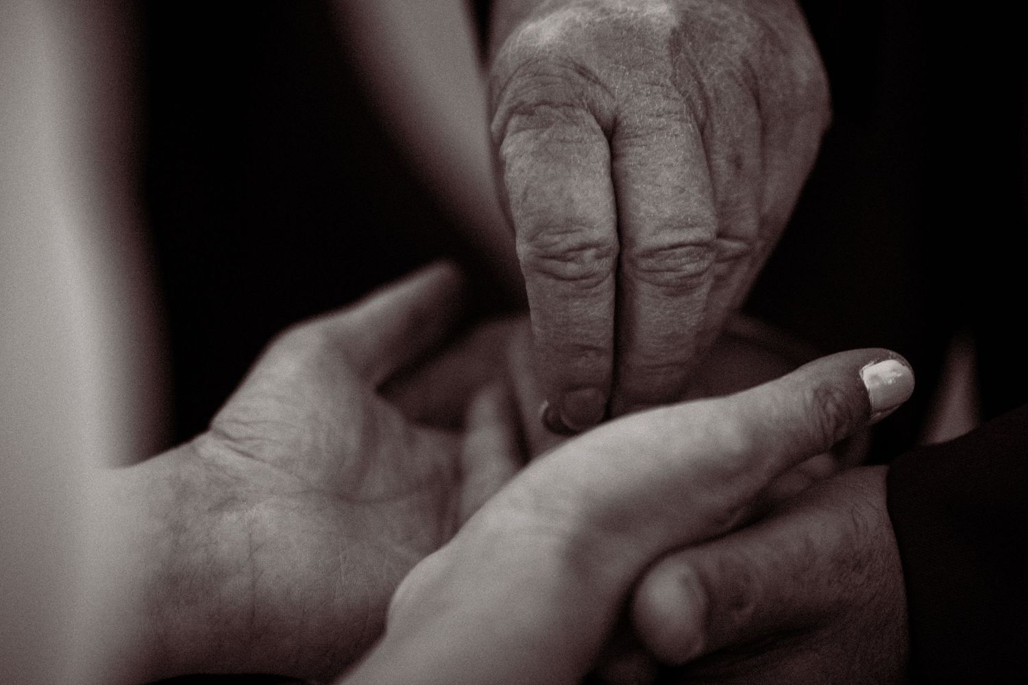 Close-up black and white photo sequence of hands in dramatic lighting.