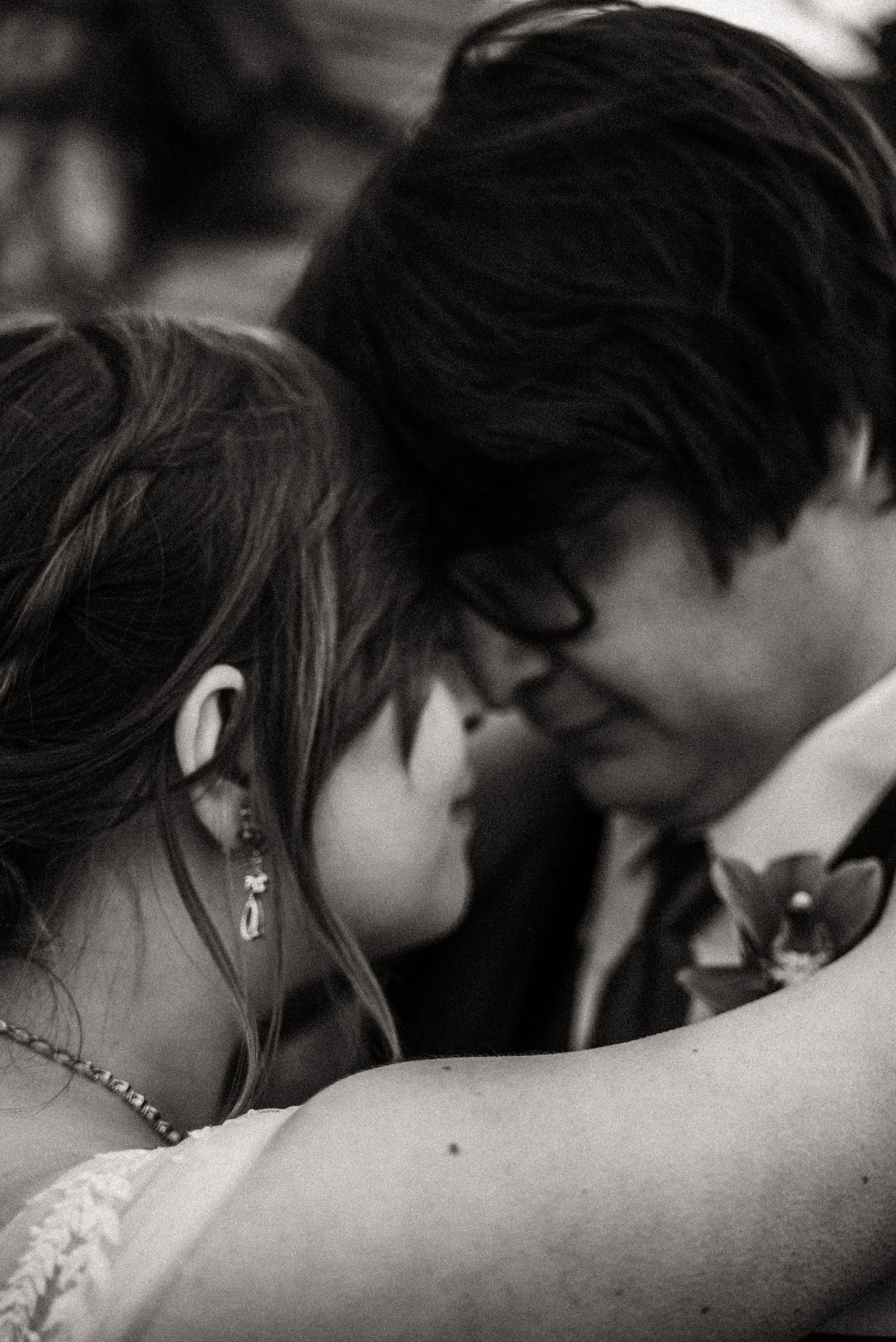 A black and white intimate portrait of a wedding couple sharing a tender moment.