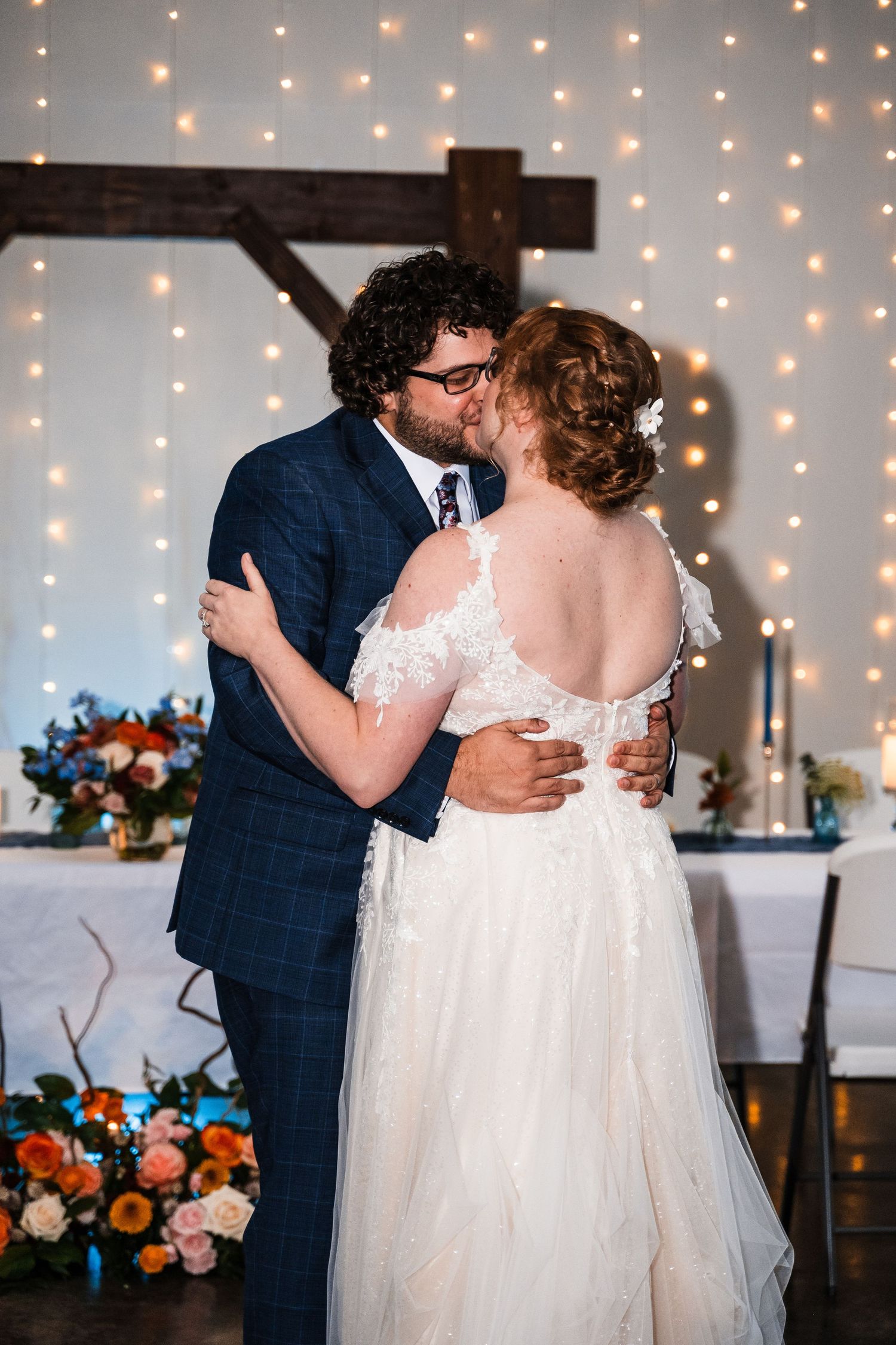Intimate dance moment with twinkle light backdrop at wedding reception.
