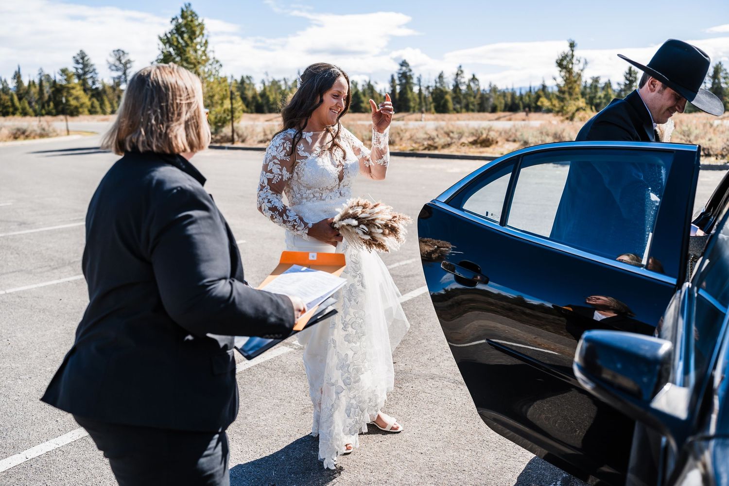 Couple shares intimate moments by a black car during their winter wedding celebration in the mountains.