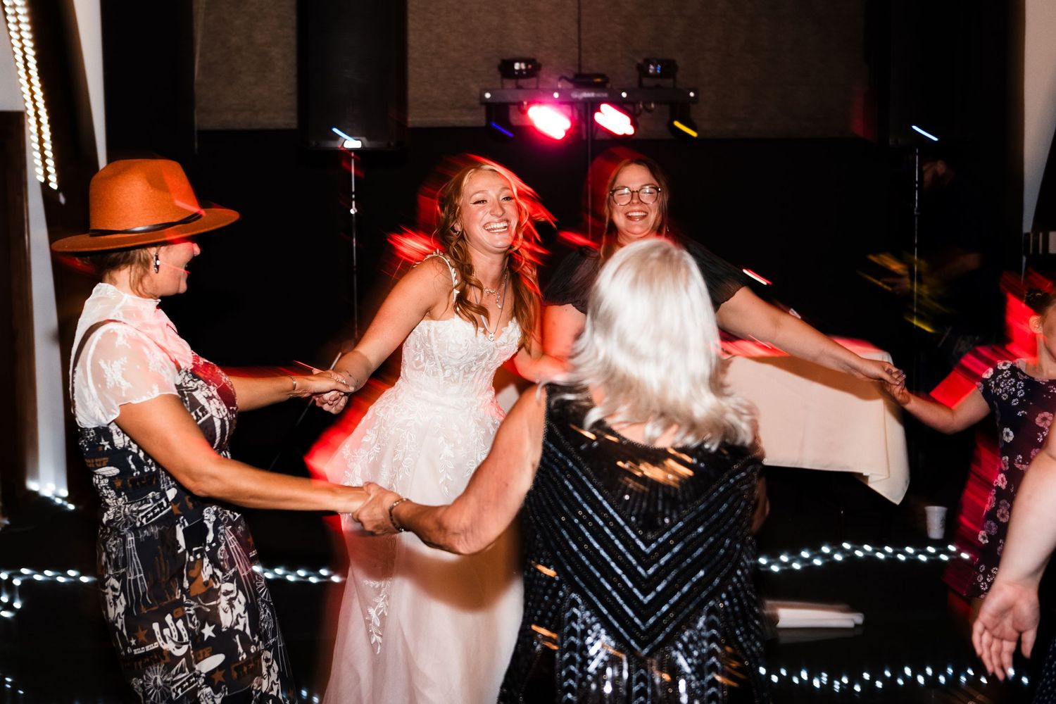 Wedding reception dance floor filled with celebration and colorful lighting.