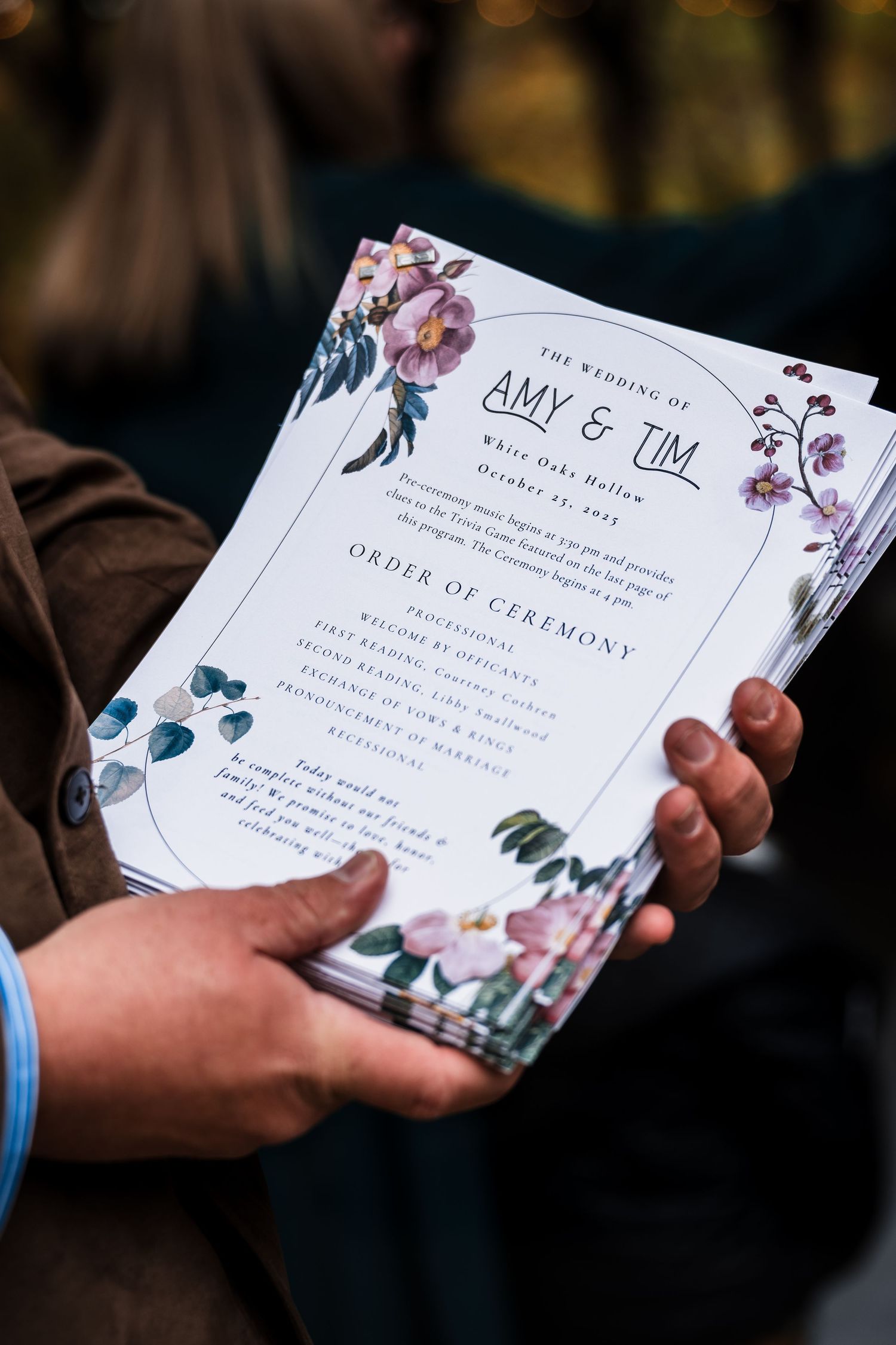 Wedding ceremony programs with floral designs are displayed against a dark background.
